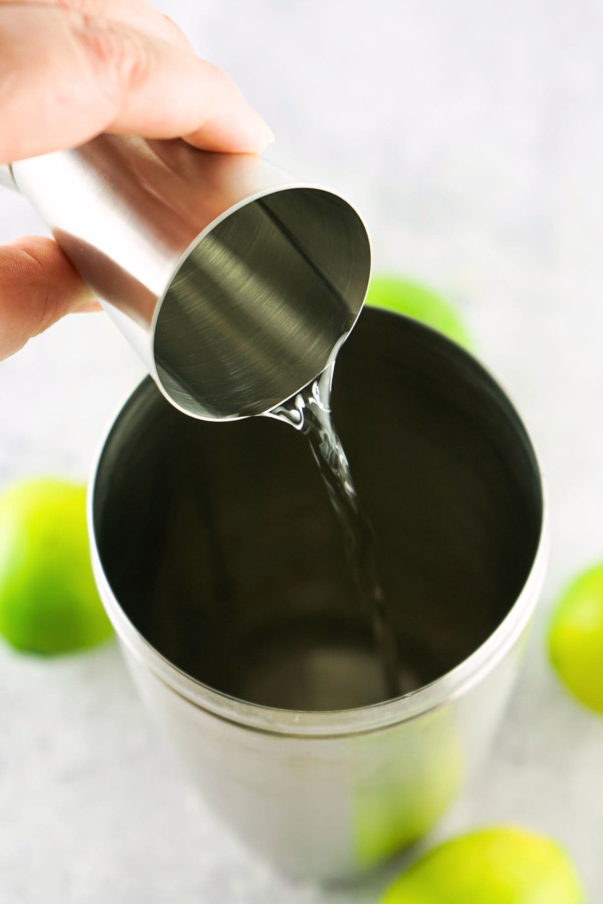 Pouring tequila into cocktail shaker.